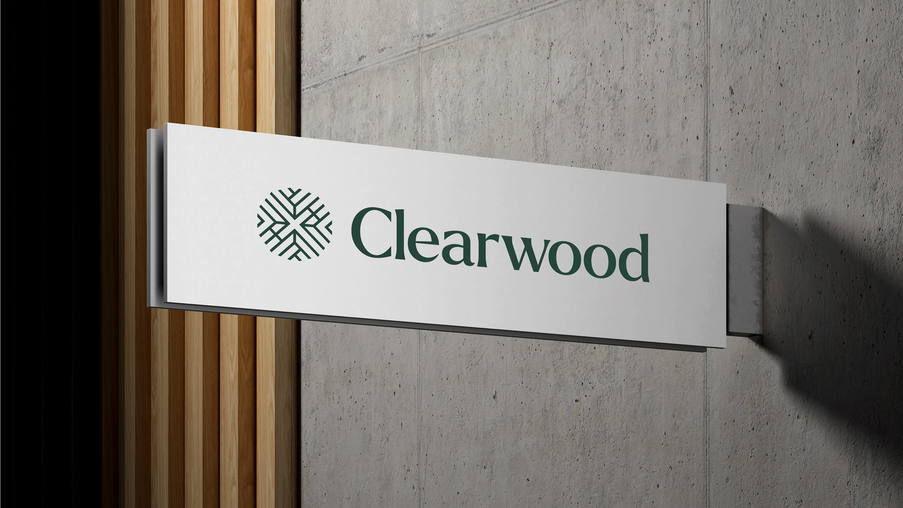 Modern white signage against a concrete and wooden slat wall with the logo in green