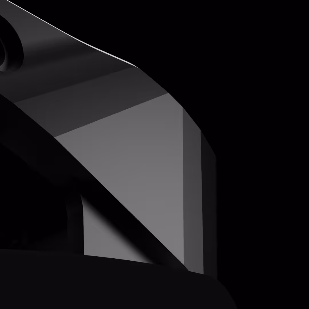 Close-up of a sleek black prosthesis foot with a smooth, angular glass surface against a black background.