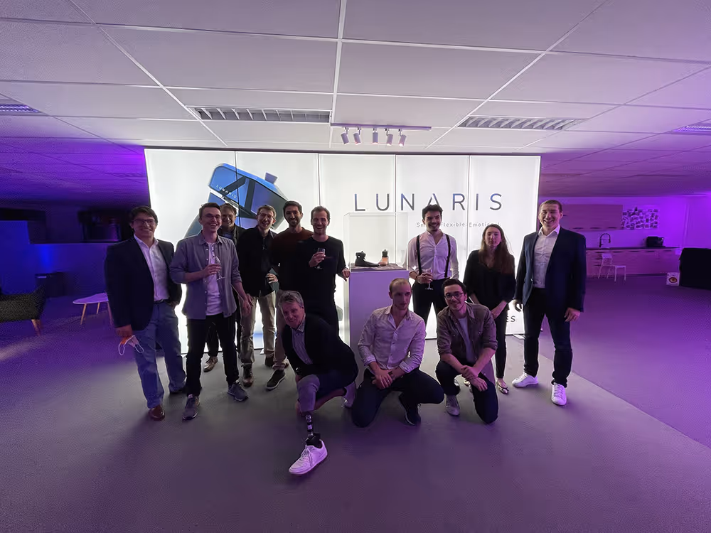 Axiles team posing together during an event in a modern indoor setting