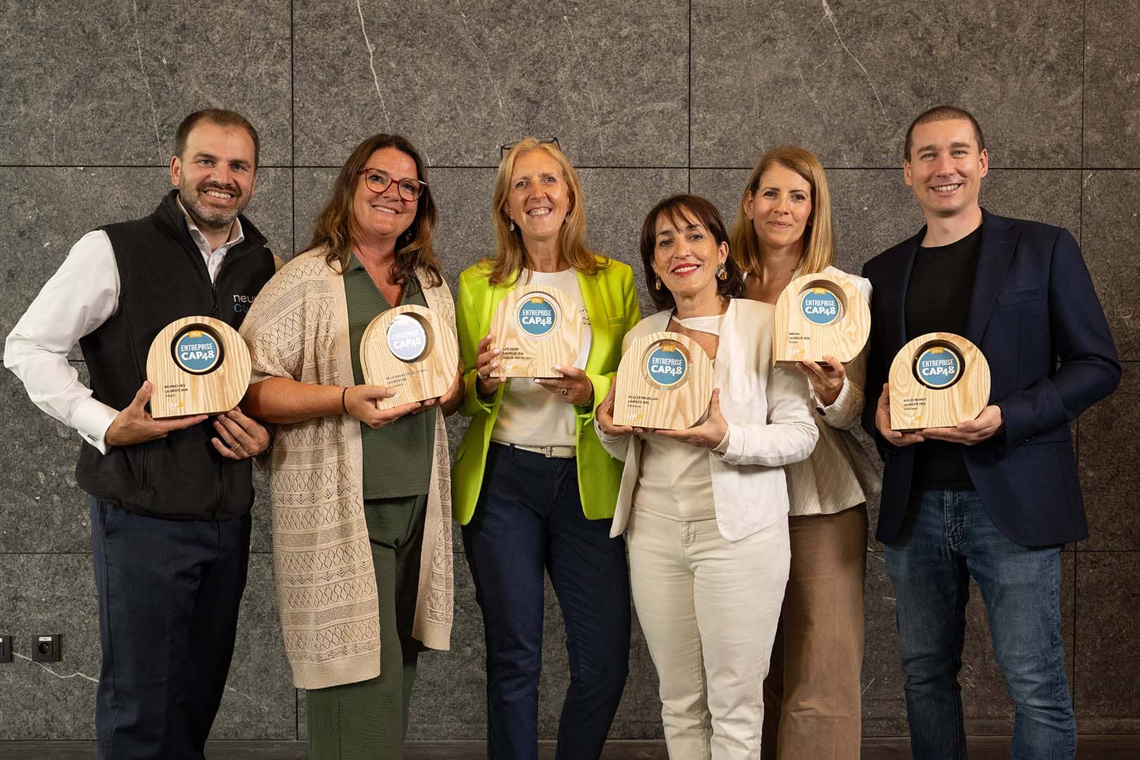 Six CAP48 Enterprise Award 2026 laureates holding their awards after being recognized for their contribution to disability inclusion.