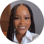 Smiling woman with long braided hair wearing a white collared shirt.