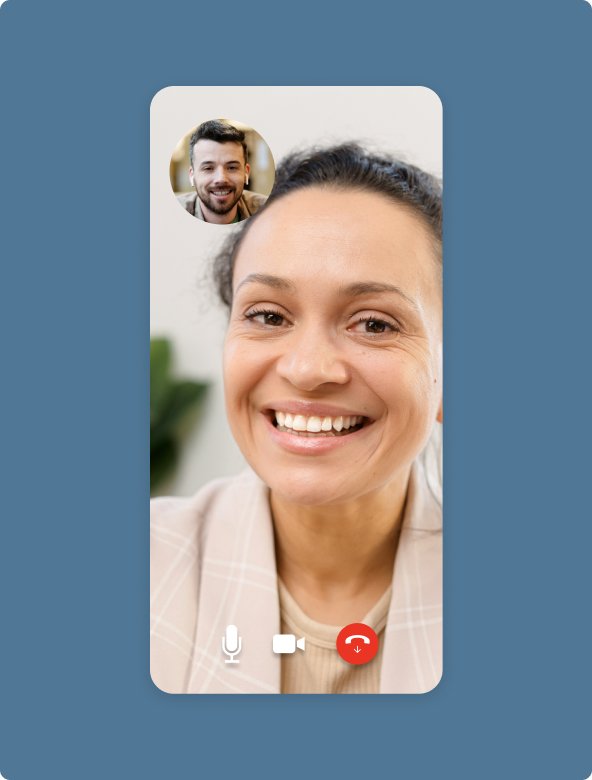 Video call screen showing a smiling woman in the main frame and a smaller inset of a man also smiling, with microphone, video, and hang-up icons at the bottom.