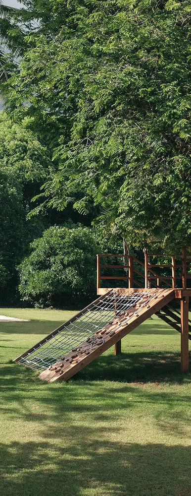A man is standing on the beach wearing traditional attire