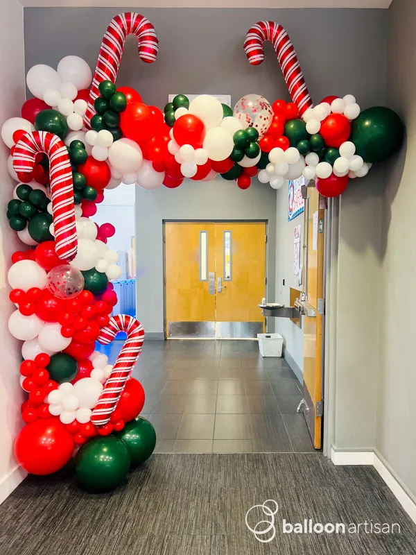 A balloon candy cane and balloon christmas garland for an entryway at a company party.