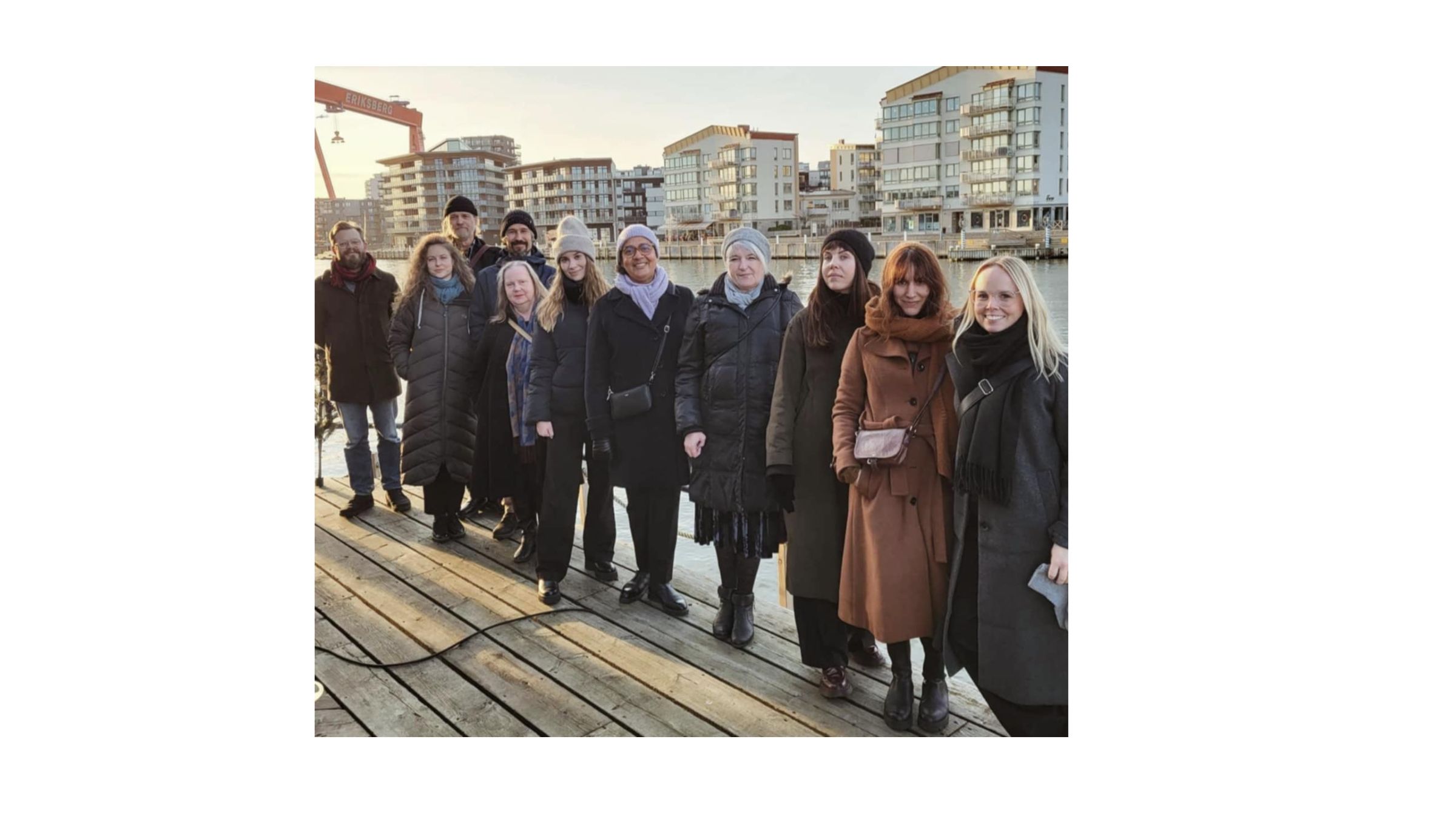 Nio ShareMusic medarbetare har samlats i ett rum på ett hotell. Några av dem sitter framför ett kaffebord med tända ljus och några står bakom. Några av dem ler. De som är med på bilden är Moa Johansson, teamledare, längst till vänster, Malin Johansson, före detta projektassistent,  Katarina Hatti Isaksson, projektledare Kommunikation,  Natallia Pettersson, projektsamordnare, Jan Hansen, producent, Helena Melin, administration och ekonomi,  Eugenia Granat, projektkoordinator, Sophia Alexandersson, verksamhetschef och konstnärlig ledare, och före detta projektledare Richard Forsberg.