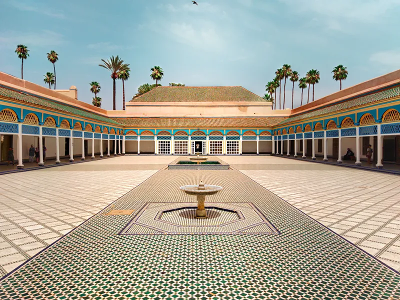 La grande cour du palais Bahia avec un ciel bleu et des palmiers comme fond