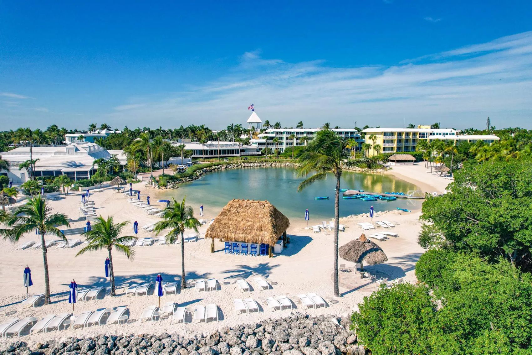 Beachfront lagoon with palms and loungers at Ocean Reef Club