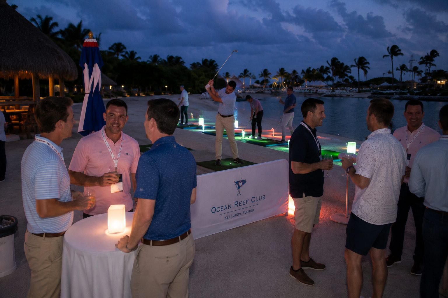 Guests talking over drinks at a waterfront evening reception at Ocean Reef Club