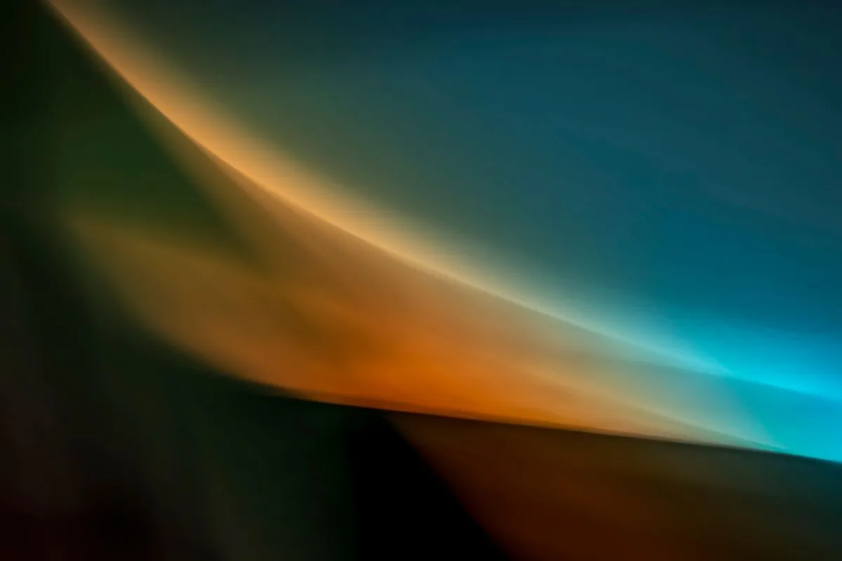 Abstract smooth gradient shapes with dark green, orange, and blue hues blending together.