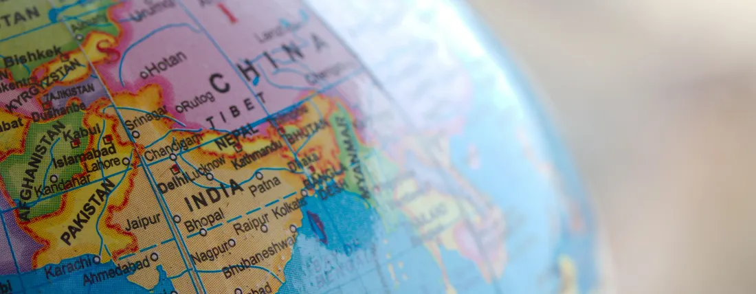 Close-up of a globe showing countries including India, Pakistan, Afghanistan, and China.