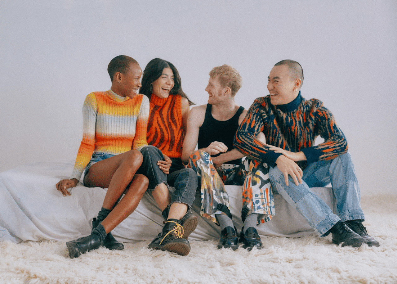 A group of four friends smiling and laughing with each other