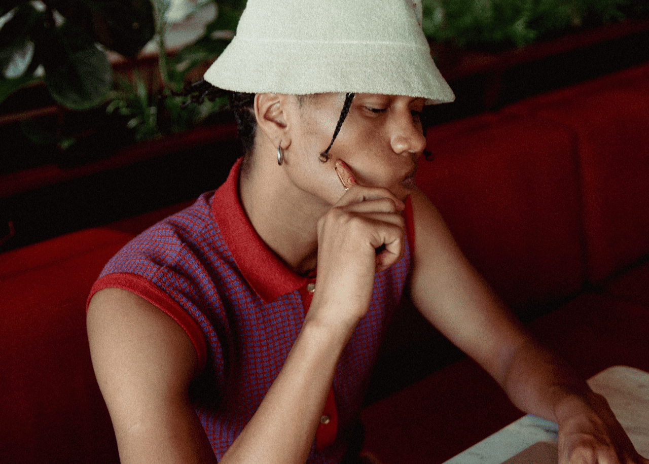 A queer person looks off to the side