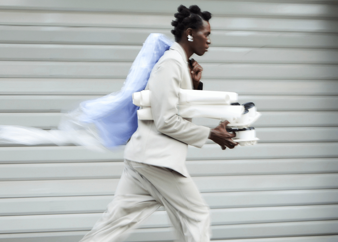 Person walking to work holding a coffee and bag