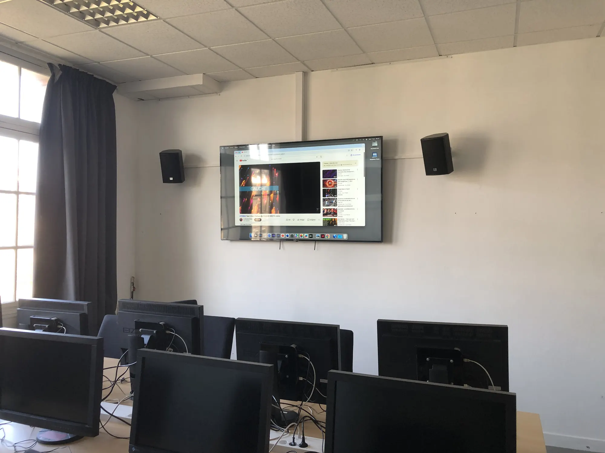 Enceintes murales et écran installés dans une salle de formation