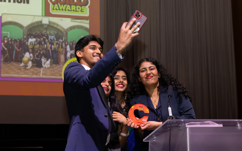 A group of students taking a selfie with their award. 