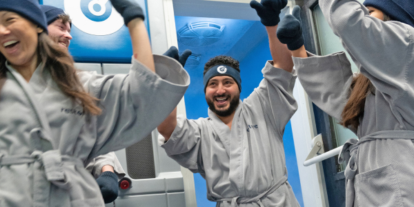Men and women exit Cryotherapy chamber cheering at Restore Hyper Wellness