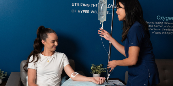 Woman gets NAD+ IV Drip from Nurse at Restore Hyper Wellness for metabolism, energy and longevity