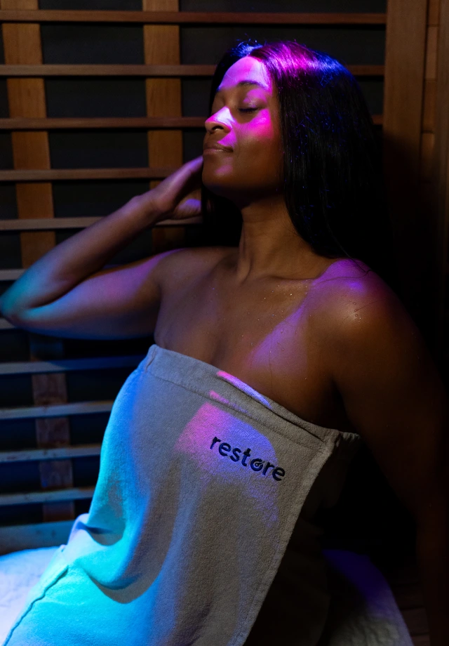 A young woman in a rob relaxing in an infrared sauna