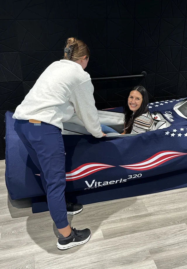 Restore nurse assisting a customer in a hyperbaric oxygen chamber