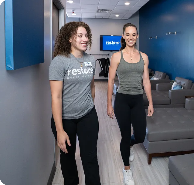 Customer with headphones getting help from store employee to start compression therapy.