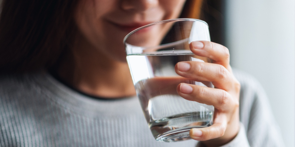 woman close up drinking a glass of water