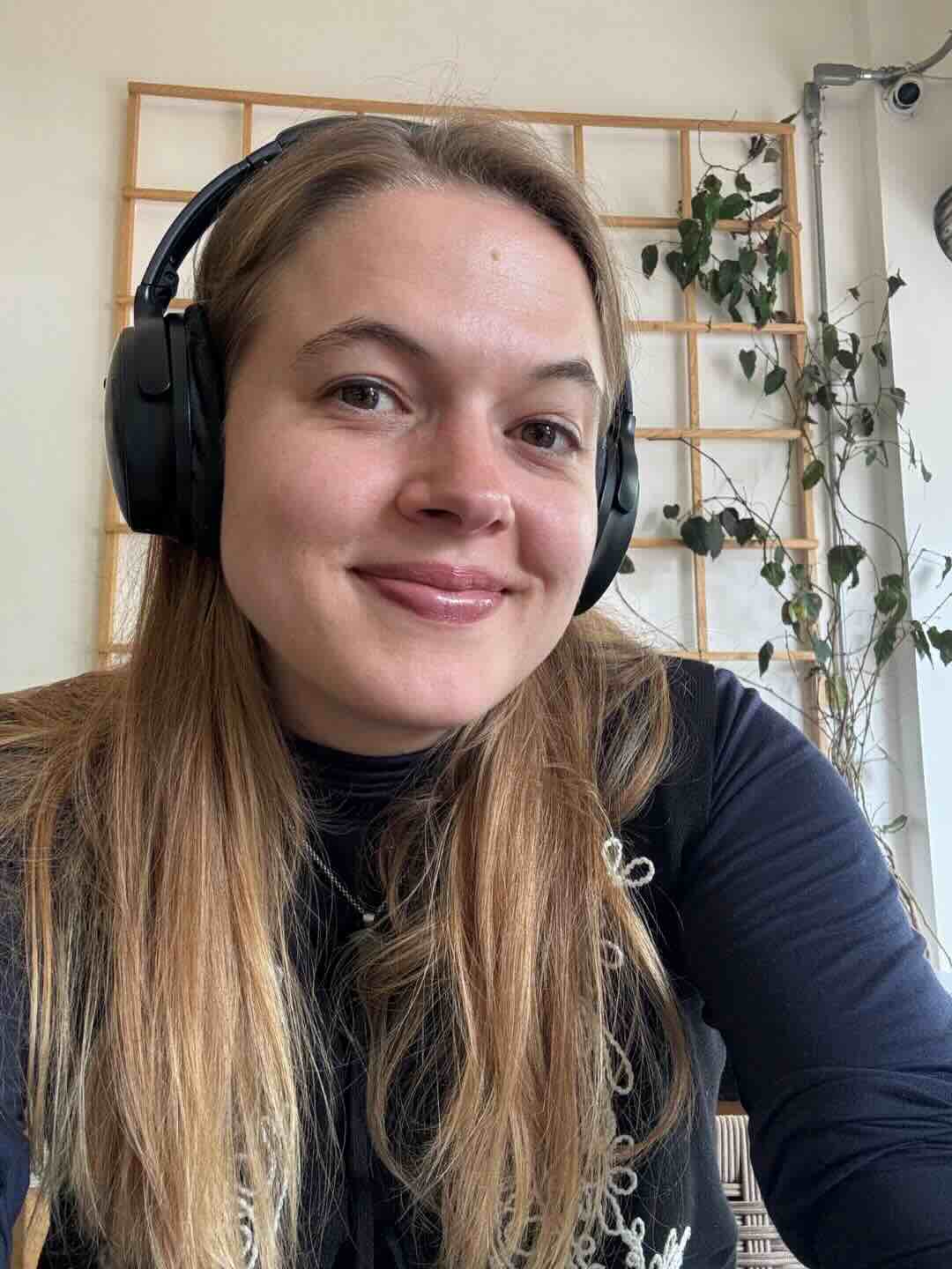 A cute picture of Tash wearing headphones in a cafe.