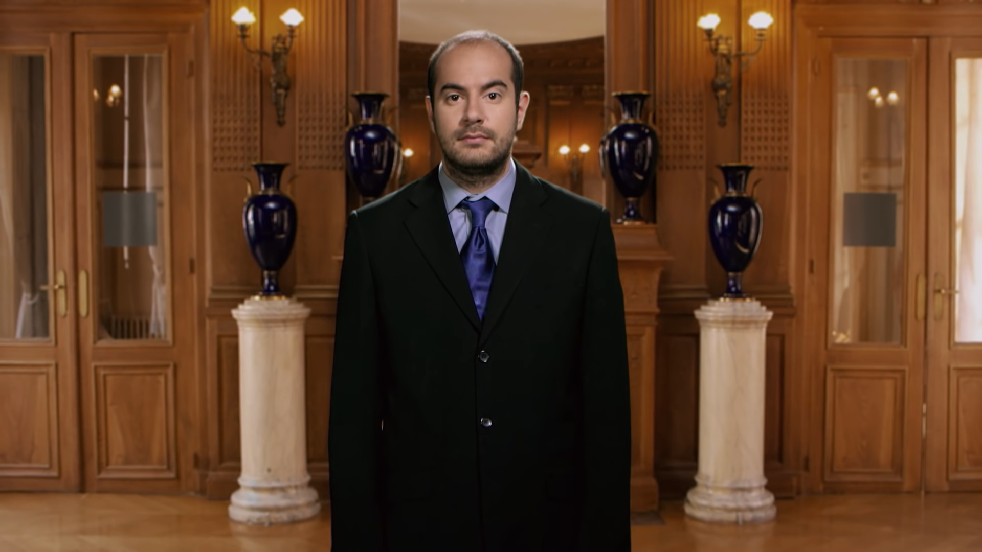 Photo de la série Bref avec un personnage en costume avec une tête blassé. Représenté par Panache