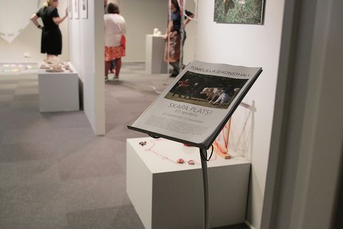 En skylt med texten Skapa Plats. I bakgrunden syns en konsthall.