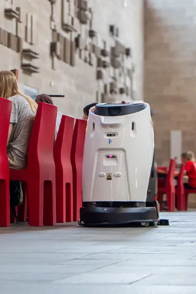 Een robot reinigt de vloer in een drukbezochte ruimte, voor een altijd schone en representatieve omgeving