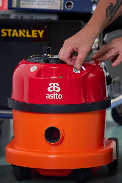 Asito-medewerker keurt een schrobmachine op locatie en registreert de resultaten in One Go.