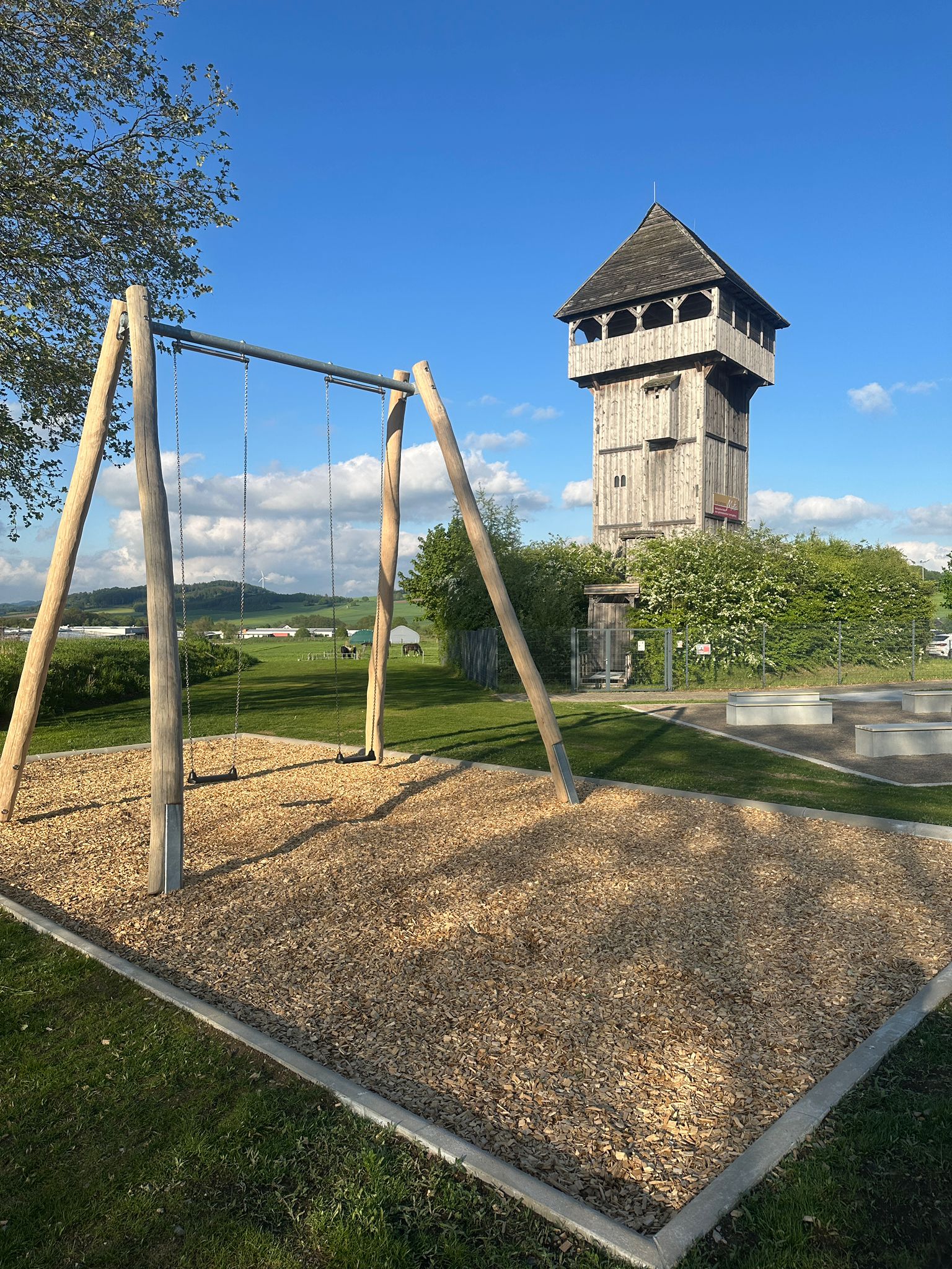 Sitzmöglichkeiten und grüne Umgebung am Spielplatz an der Motte