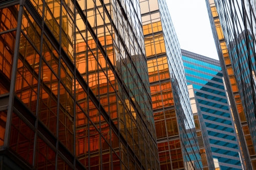 Modern glass office building reflecting skyline