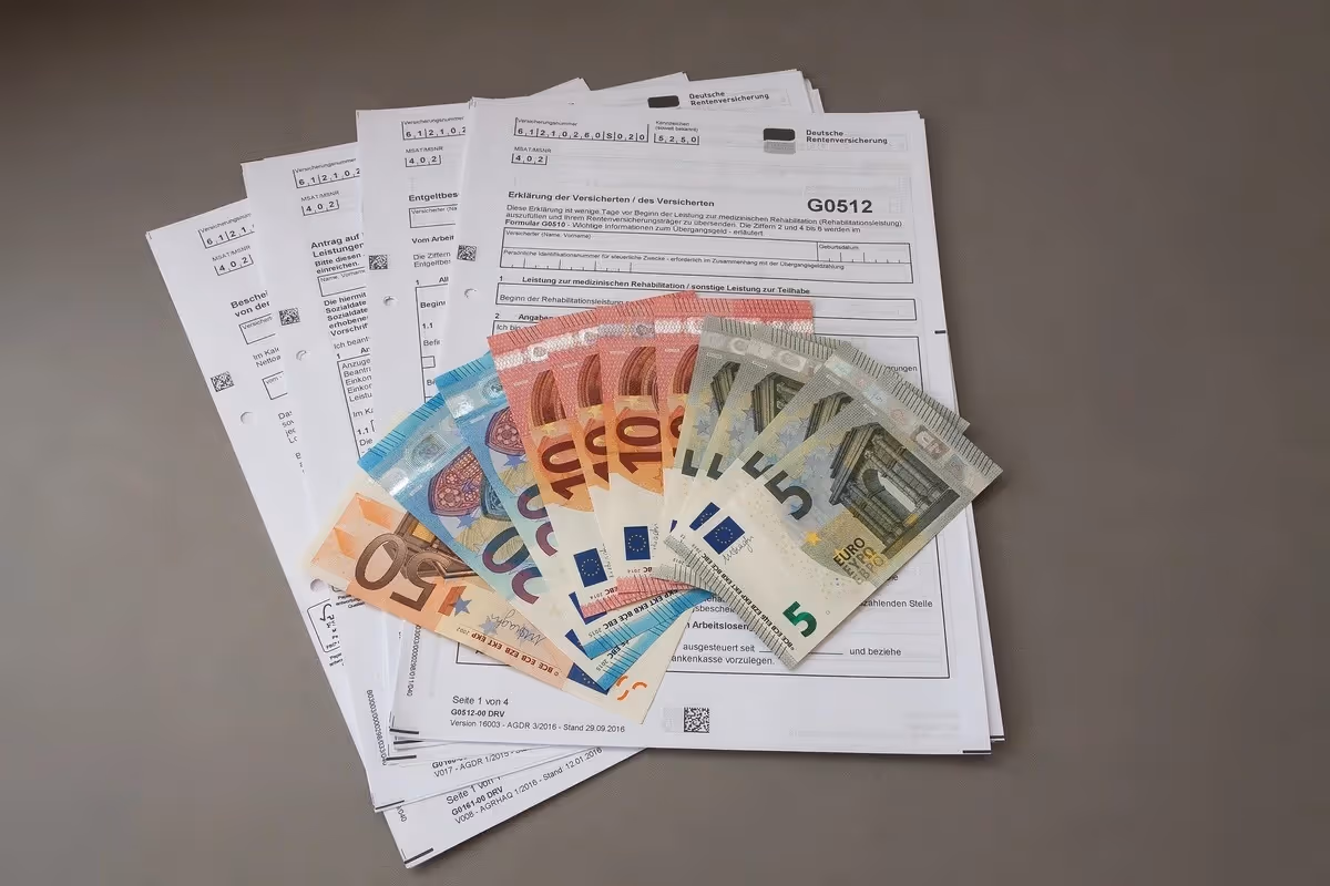 Geldscheine liegen auf Vertragsunterlagen