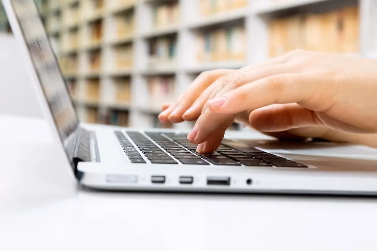 Eine Person tippt auf einem Laptop