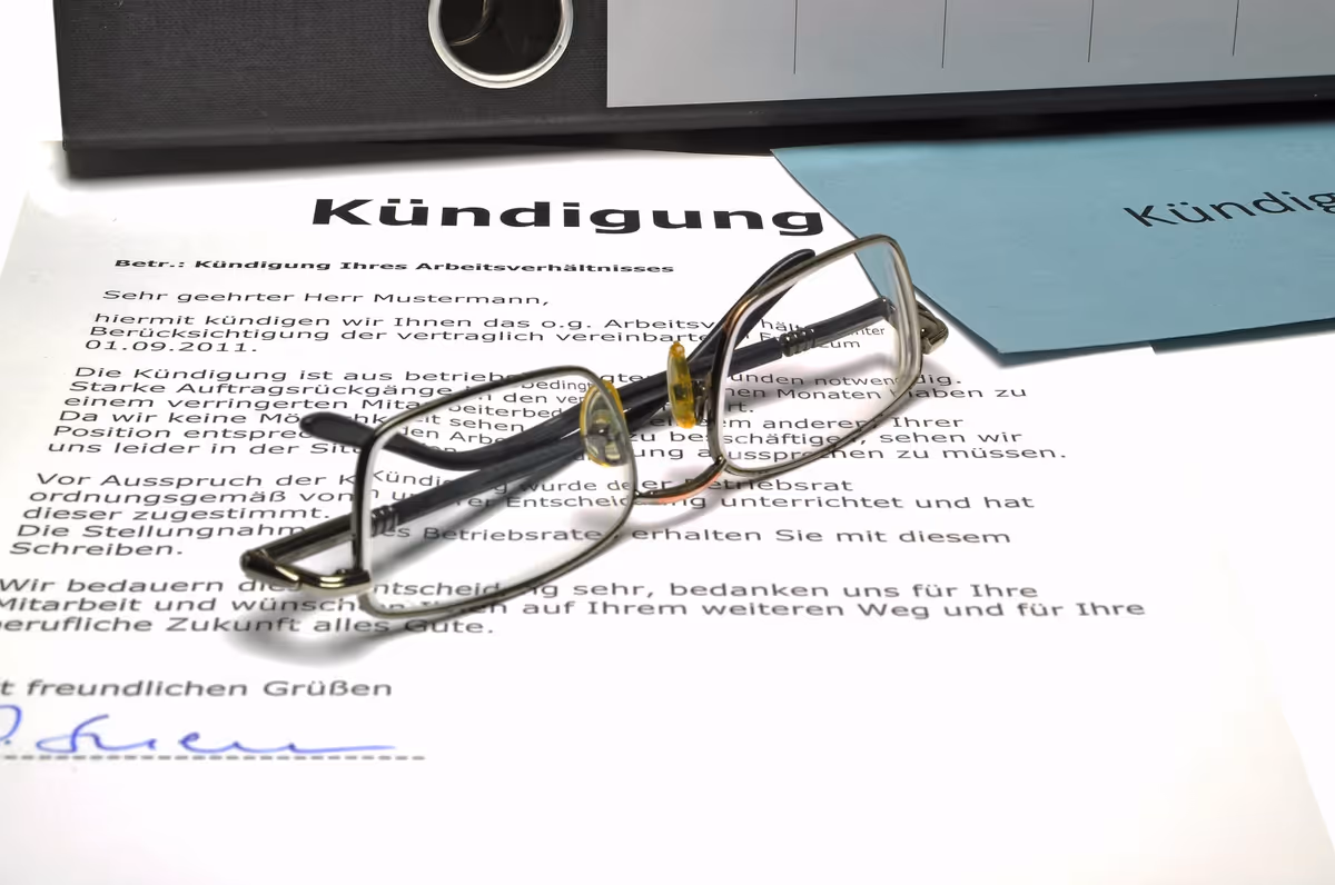 Eine Brille liegt auf einem Kündigungsschreiben