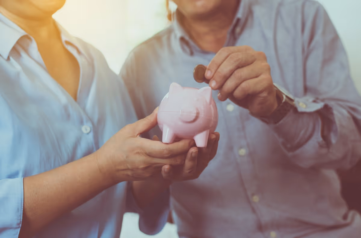 Ein Paar wirft Geld in ein Sparschwein