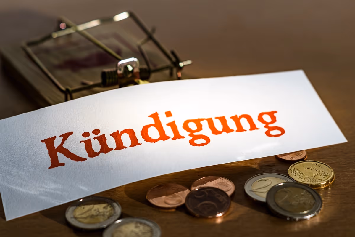 Ein Schild mit der Aufschrift Kündigung auf einer Mausefalle mit Geld