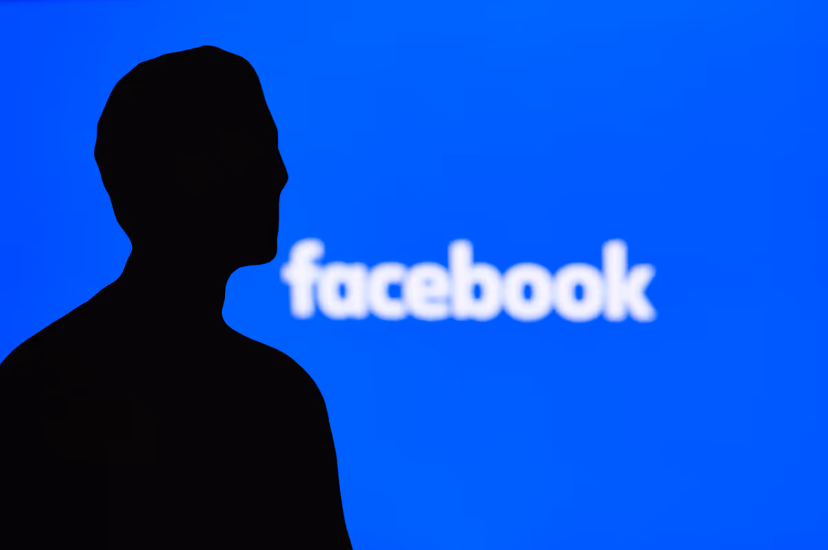Der Umriss einer Person vor dem Facebook Logo