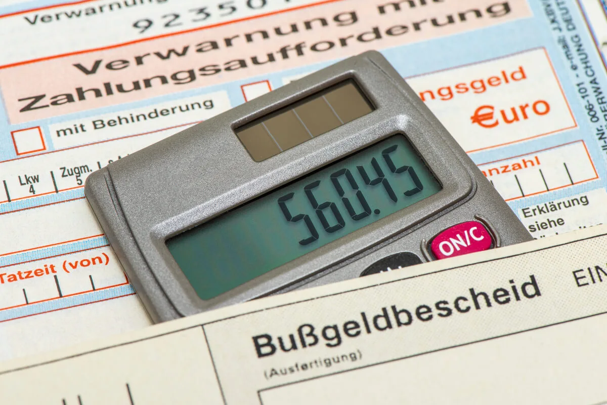 Ein Taschenrechner liegt unter einem Bußgeldbescheid.
