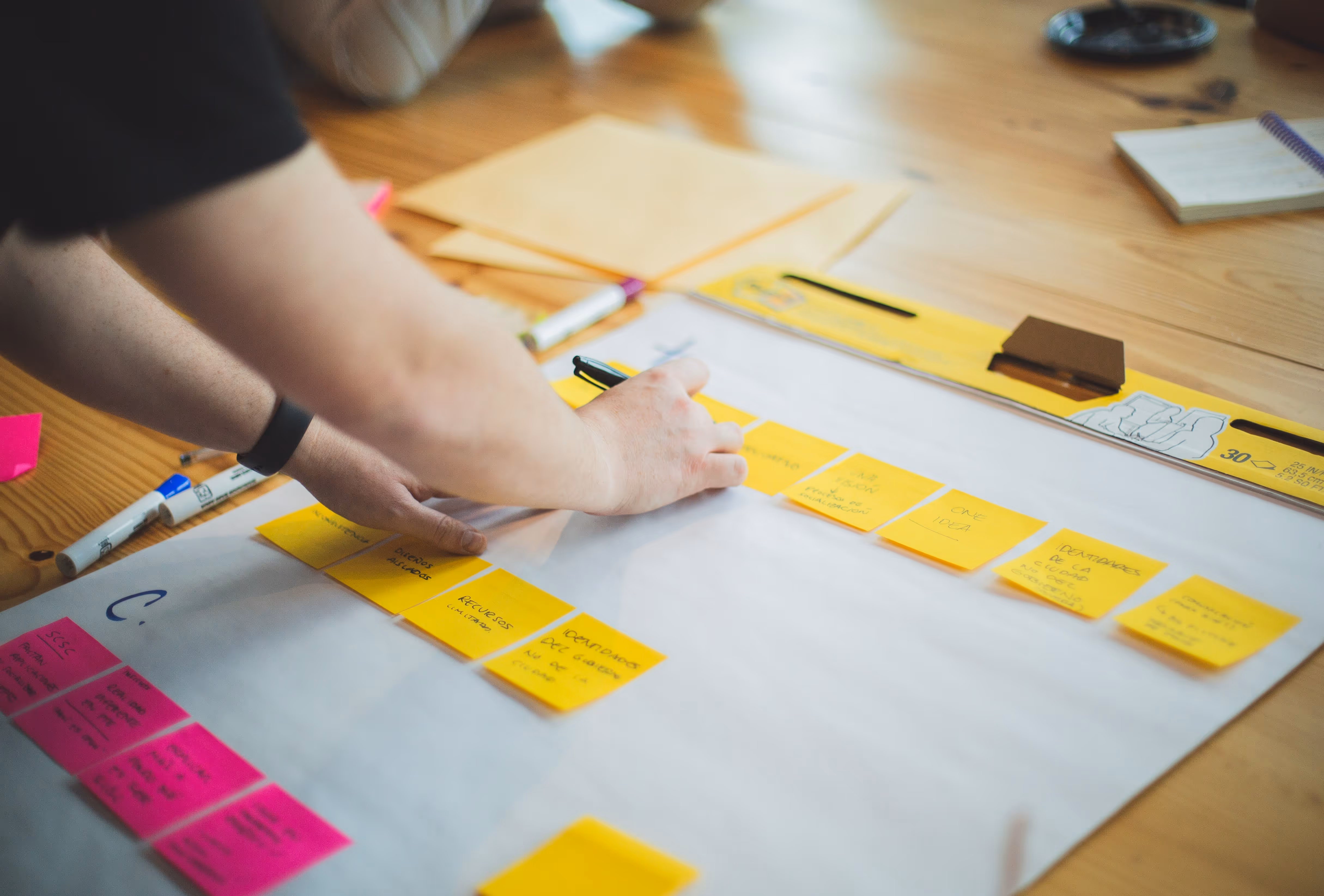A person positioning Post-Its on a notepad.