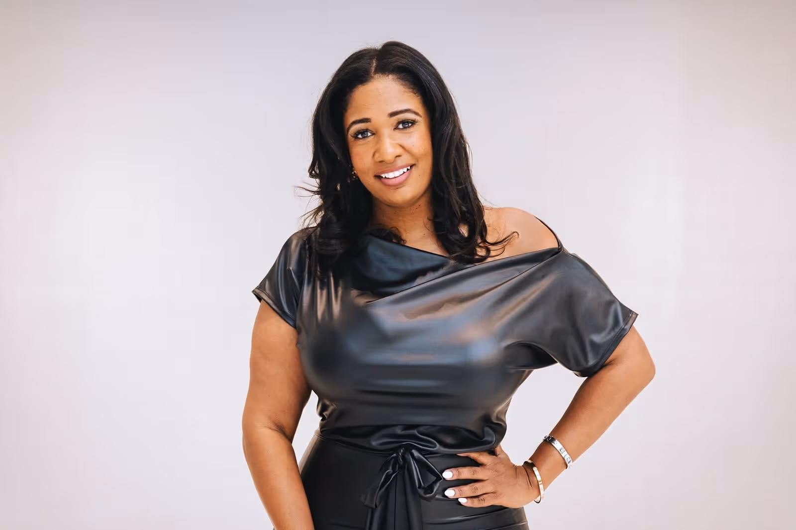 A woman in a black dress posing.