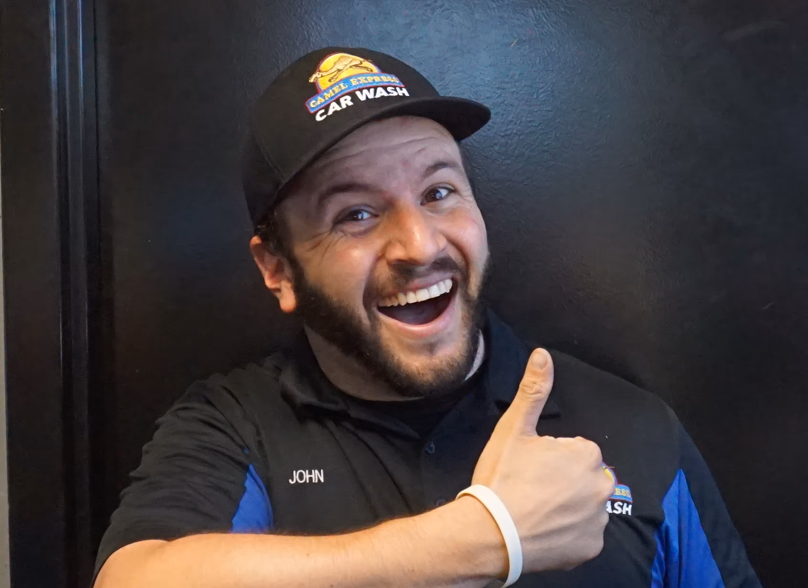 A man smiling with a thumbs up.