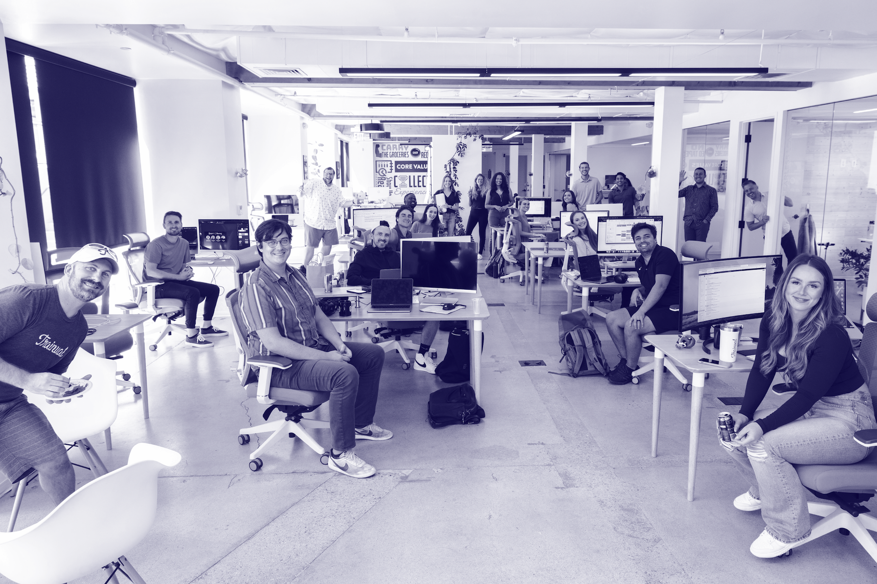 Group of people sitting at computers in an office.