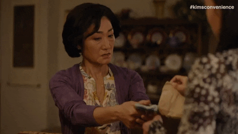 Two women exchanging cash for a bag.