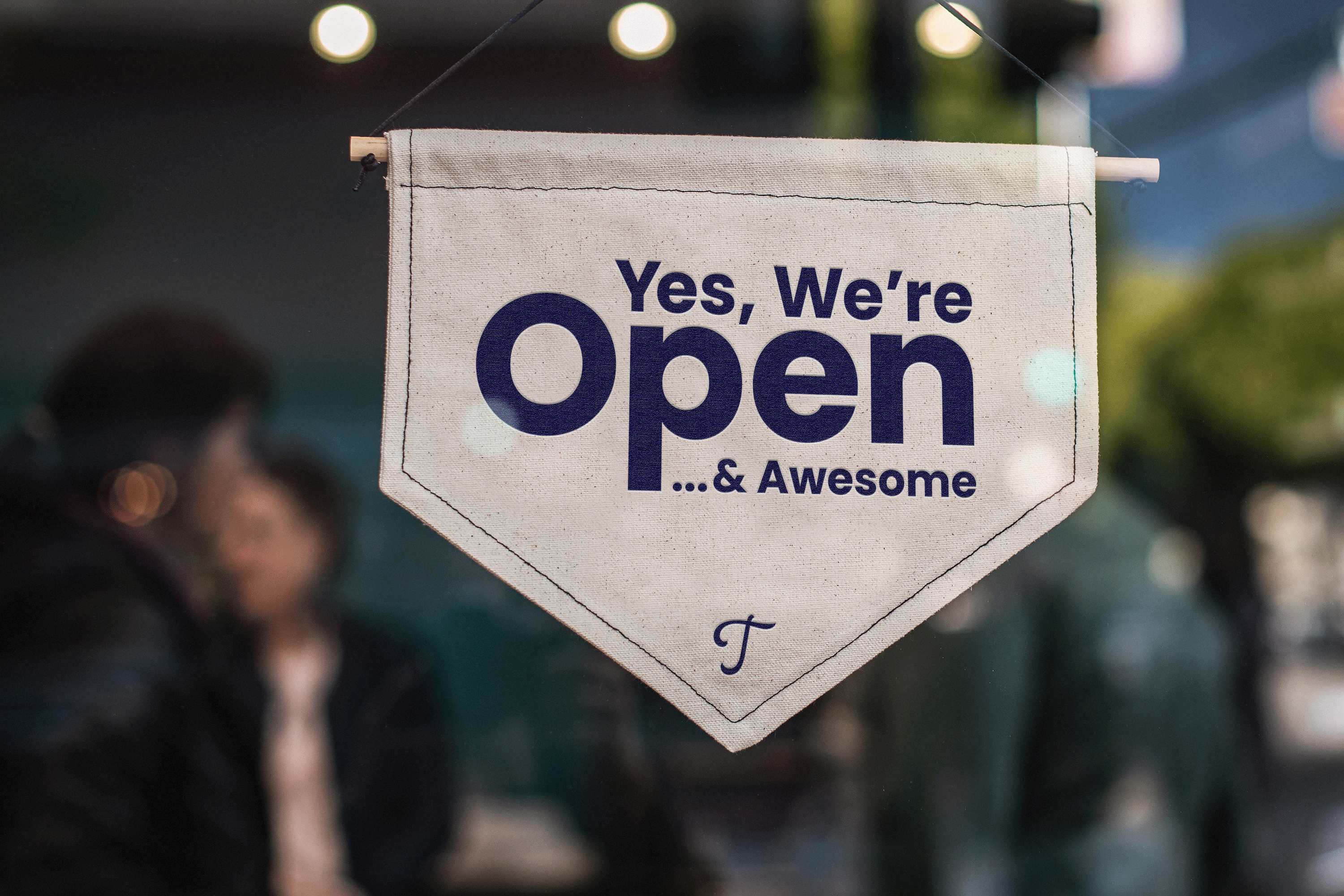 A door sign that says, "Yes, we're open... & awesome."
