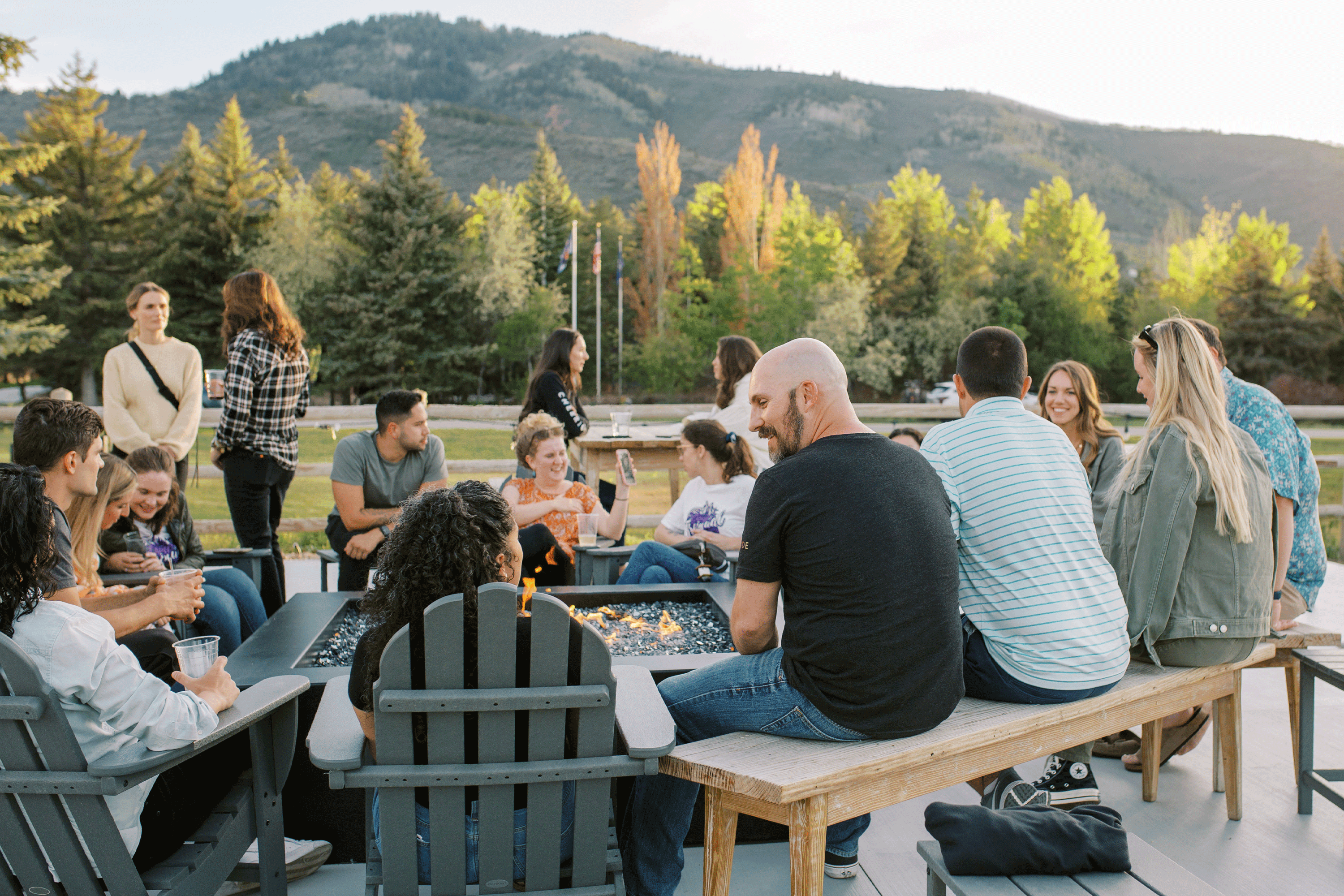 A group of people sitting around a fire pit.