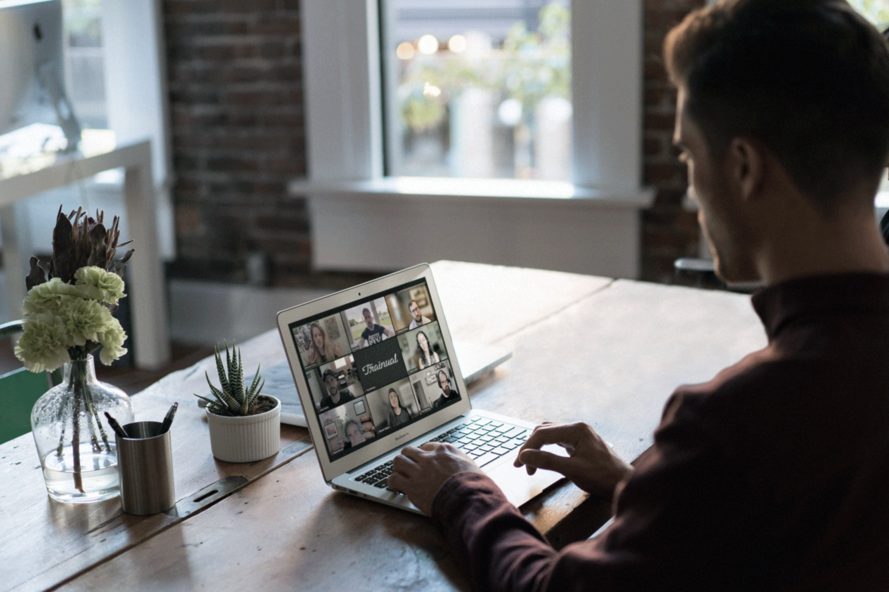 A man sitting at a laptop with a Zoom call.