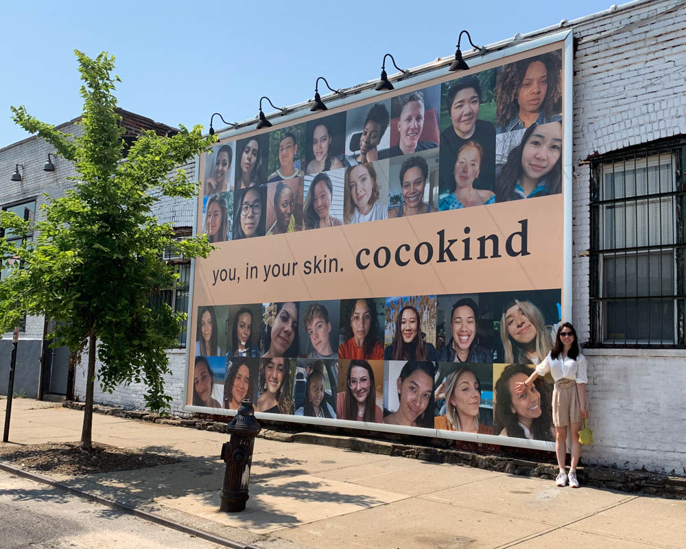 Cocokind billboard. Multiple Cocokind customers' faces.