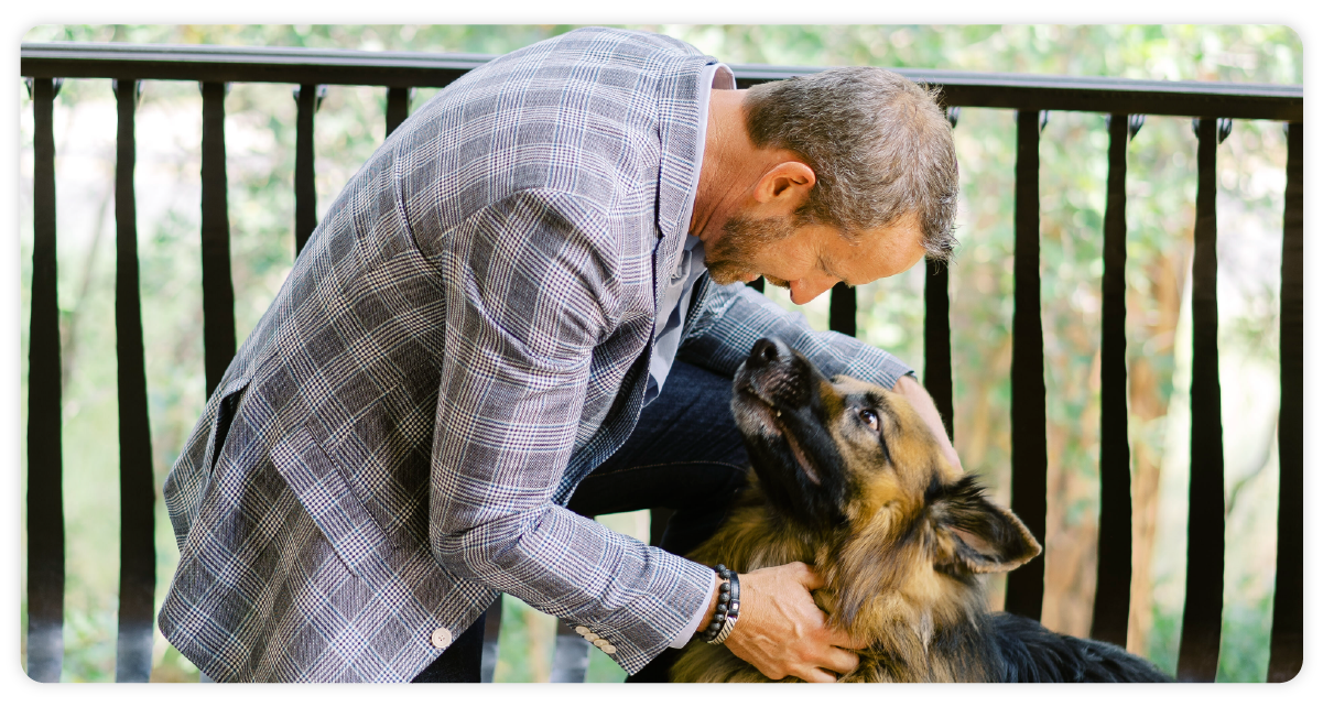 Adam Cantos, CEO of RE/MAX - playing with dog