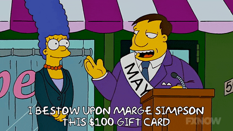 A man at a podium saying, "I bestow upon Marge Simpson this $100 gift card."